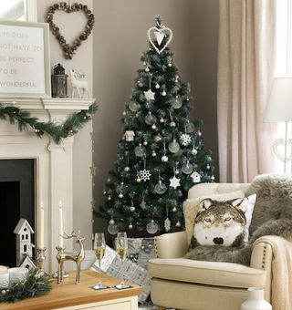 Living room with a large decorated Christmas tree and decorations on the mantelpiece