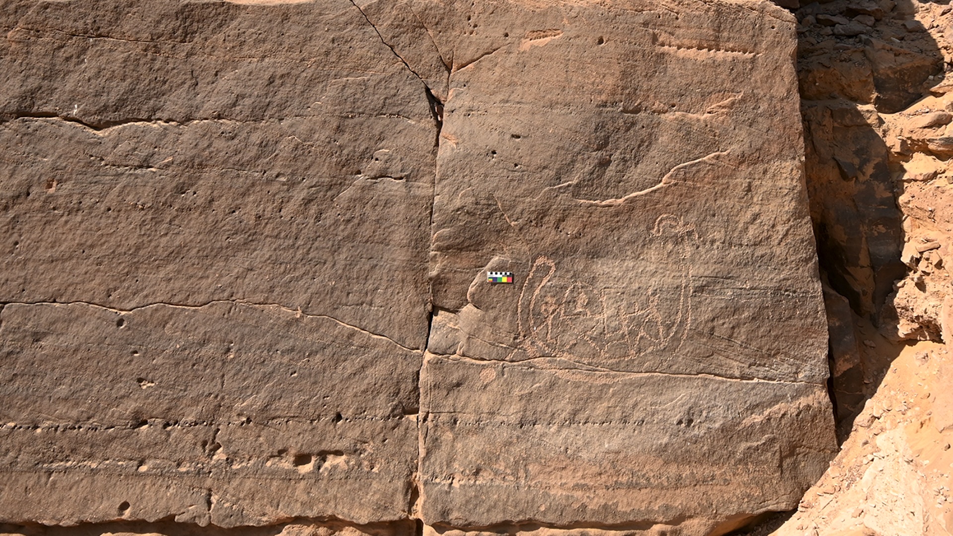 a rock carving of people and a boat