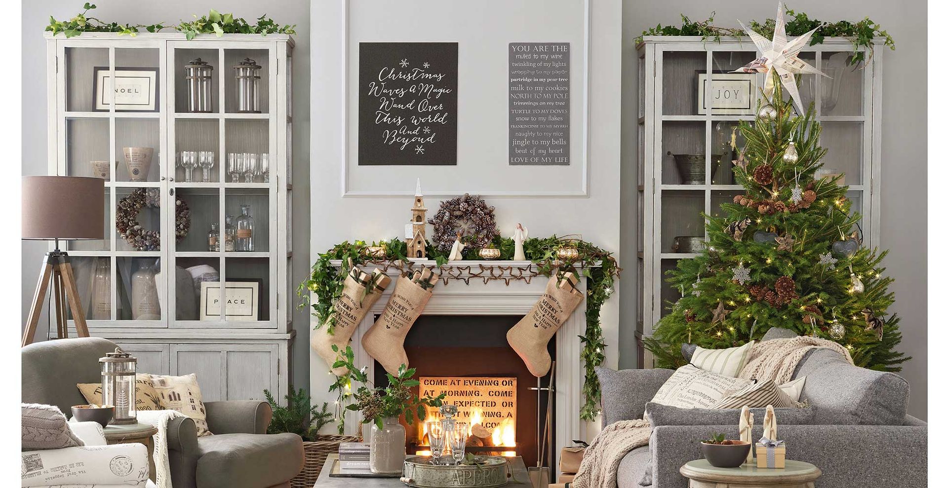 Grey living room with a Christmas tree beuatifully decorated to show how to make a Christmas tree look expensive