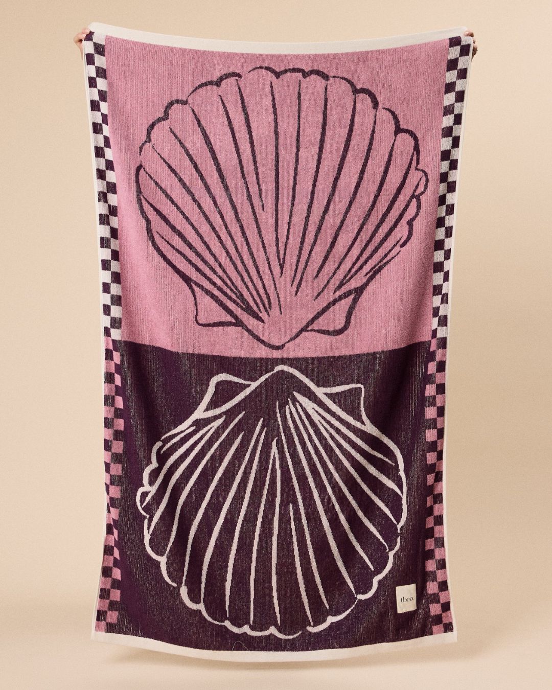 Cotton Beach Towel in Pink Shell against beige background.
