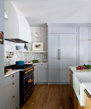 gray and marble kitchen with wood floors and black range cooker
