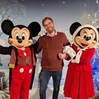 Benjamin standing between Mickey and Minnie Mouse, with a winter background behind them
