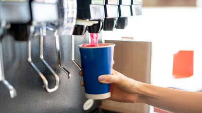 Person dispenses soda into a cup