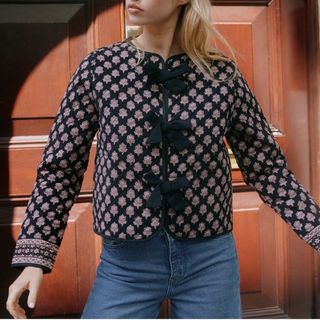 Cropped image of woman wearing pink and navy patterned jacket