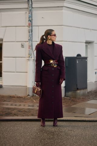 Copenhagen Fashion Week attendee wears layered belts.