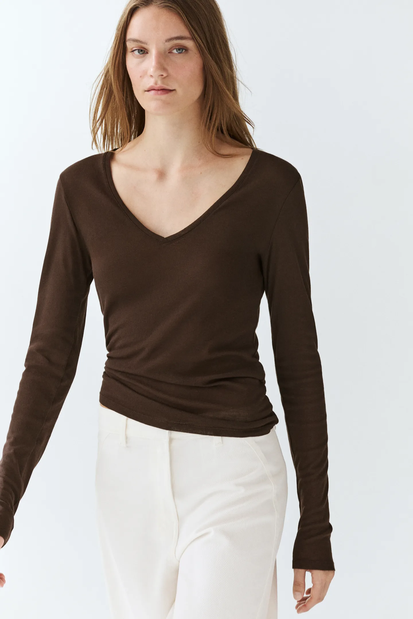 A model wears a brown long sleeve v-neck t-shirt from Massimo Dutti