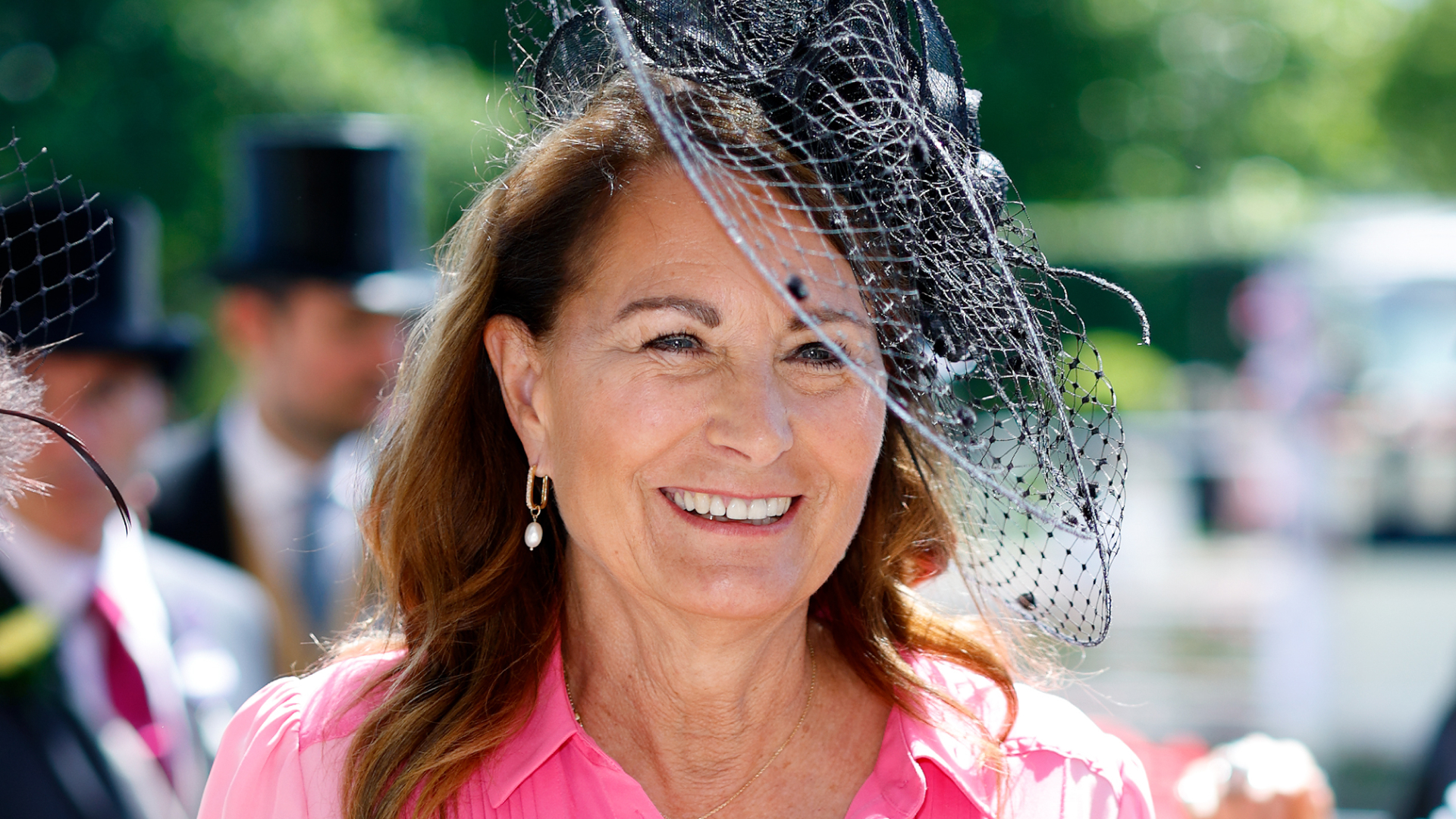 Princess Kate's mom Carole Middleton wears a bright pink dress with a black hat