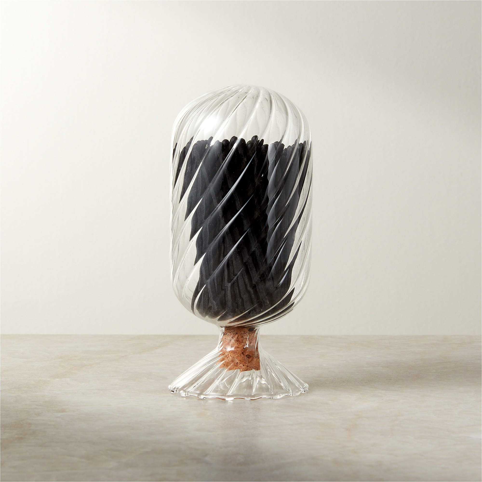Ribbed glass cloche filled with black matches