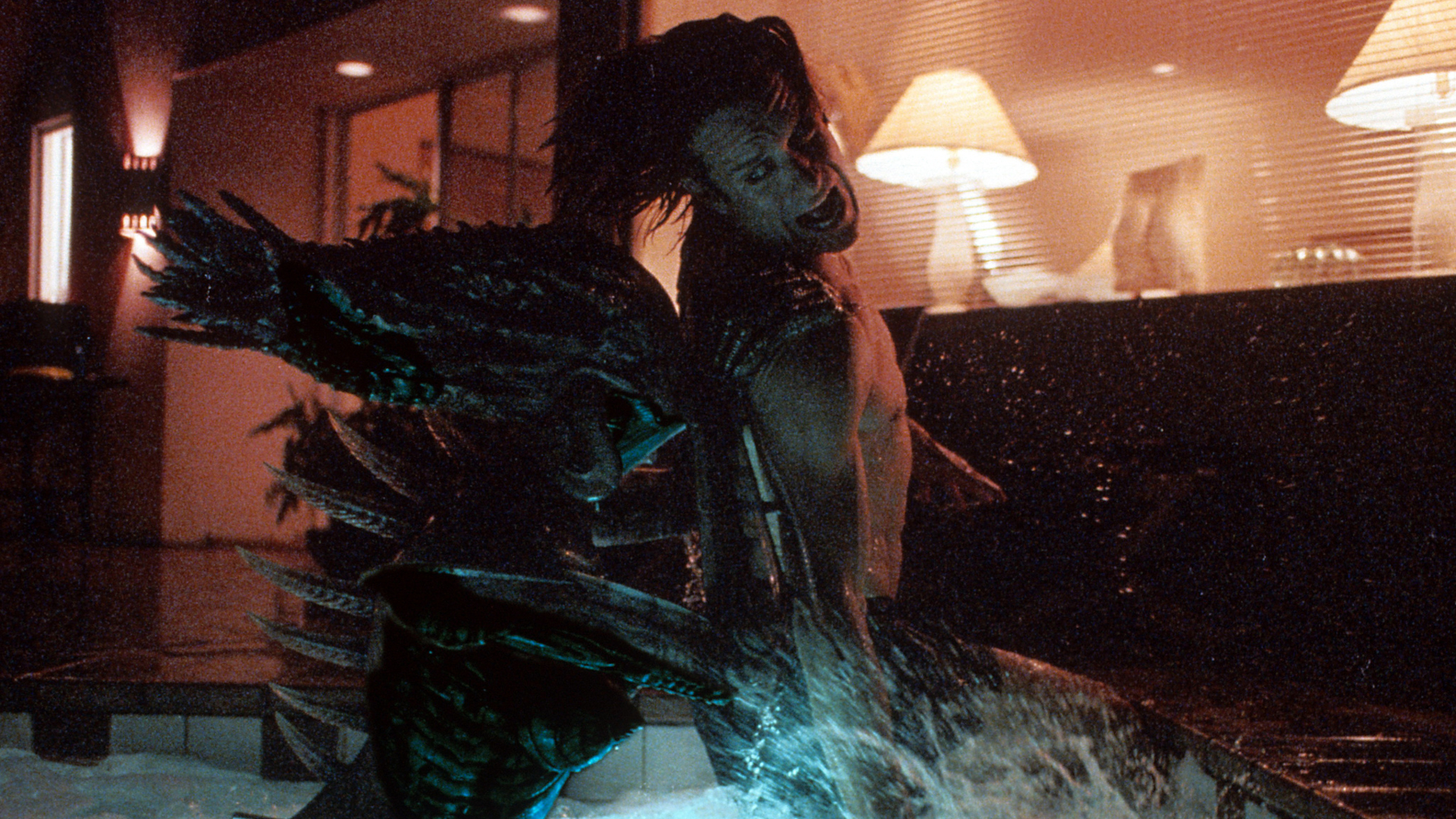 An alien creature attacks a man from behind in a swimming pool in Species (1995)