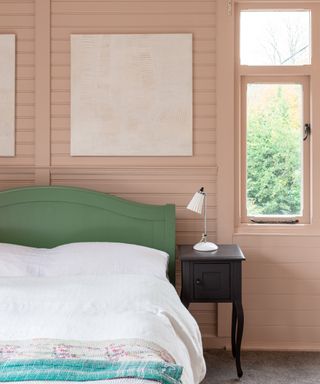 make your home feel like a sanctuary, bedroom with pink painted tongue and groove, chalet style, green bed. black side table, vintage blanket