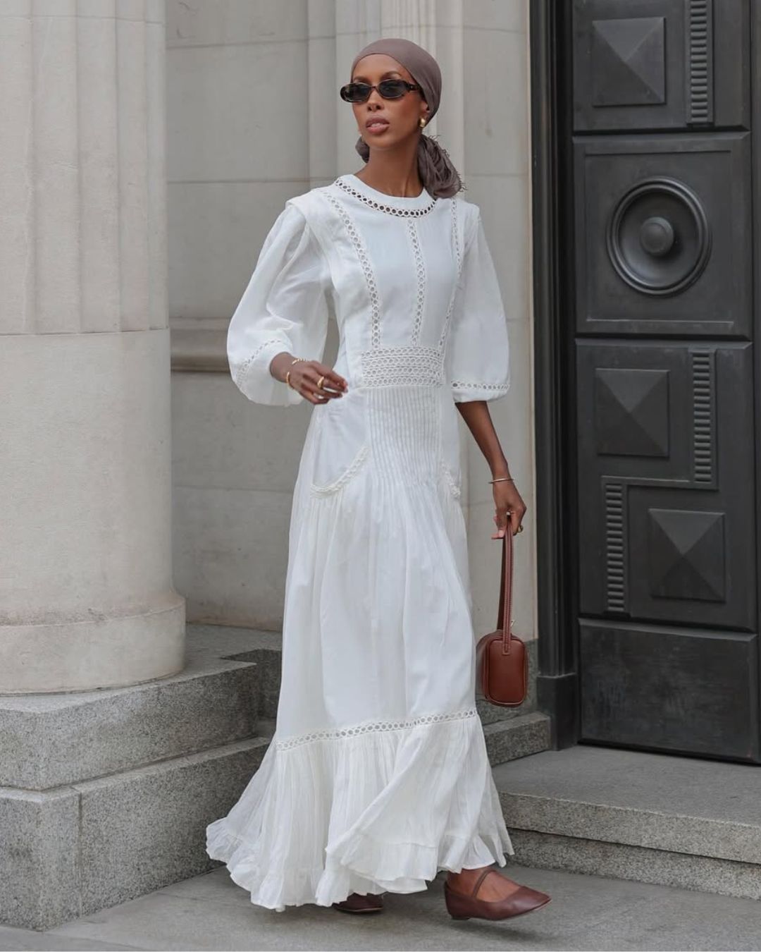 @basma_k wears a white maxi dress, tan ballet flats and a shoulder bag