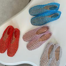 Photo of the Row jelly ballet flats on white table in red, pink, white, and blue.