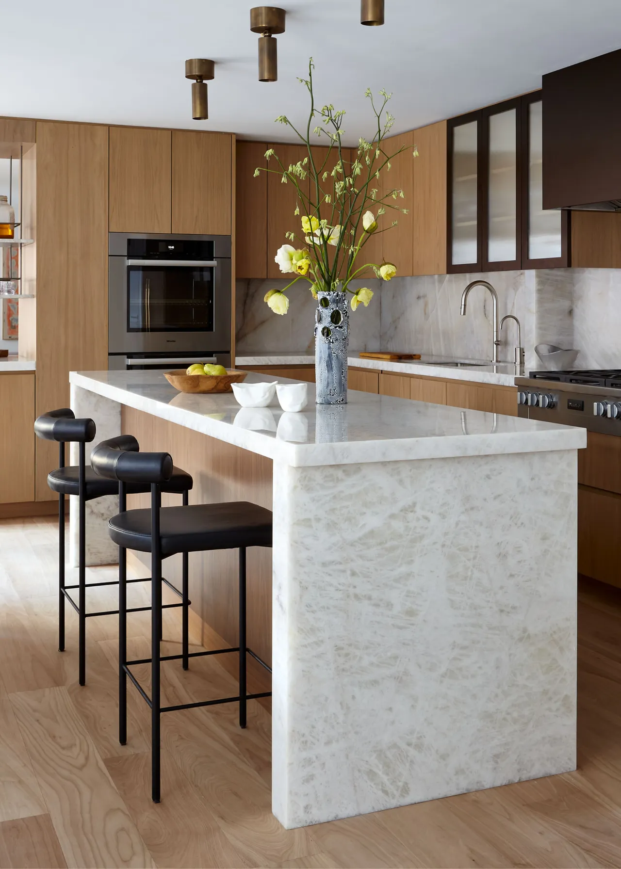 Kitchen island styled with a tall sculptural vase and spring branches to add height and balance