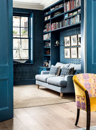 Blue living room with painted built in storage and window frames