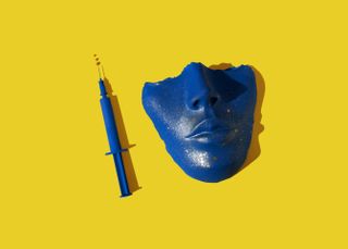 a blue ceramic face and needle on a yellow background