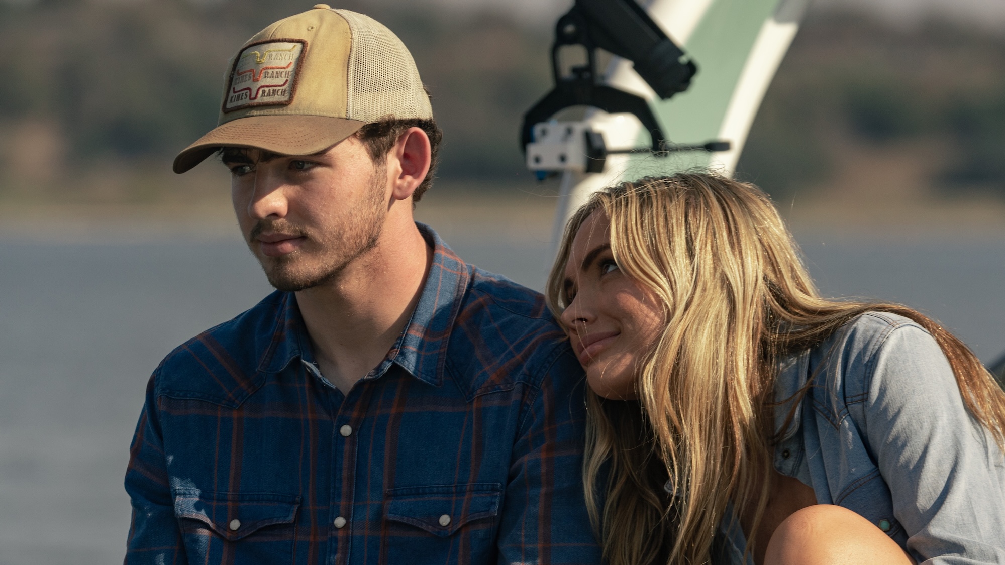 Oreana with her head against Carter's shoulder as they sit on the back of a boat in Dutton Ranch Season 1