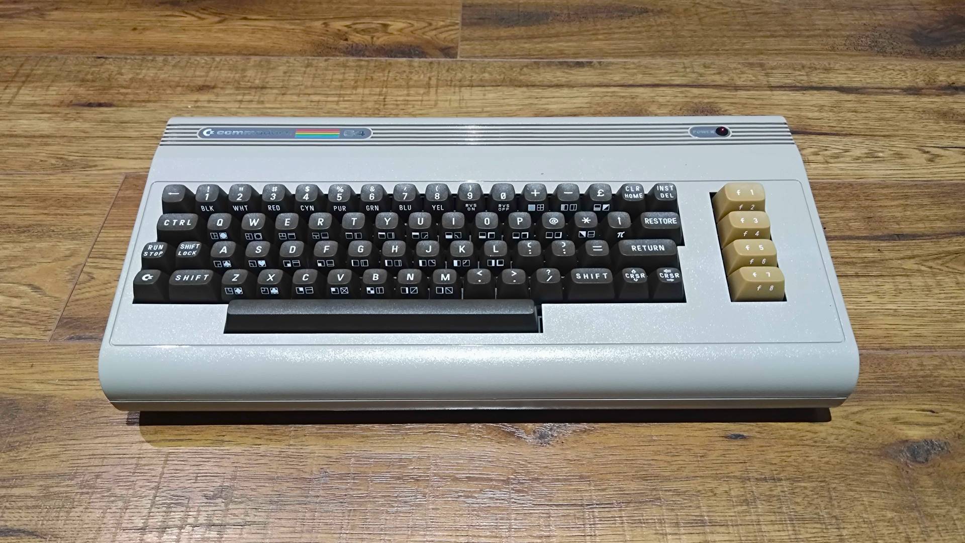Beige Commodore 64 Ultimate on wood floor.