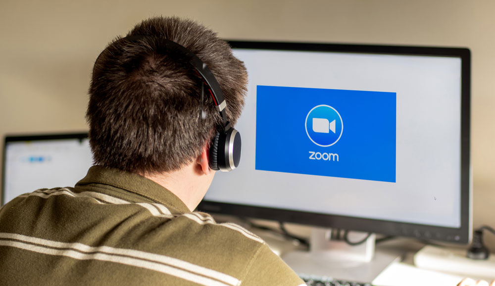 Man joining a Zoom meeting displayed on his computer's screen.