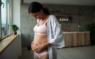A woman feeling baby movement in pregnancy