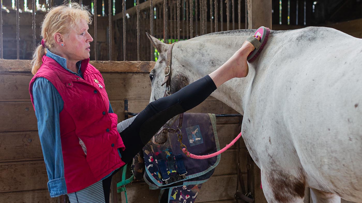Philippa brushes her horse Melitta using her feet