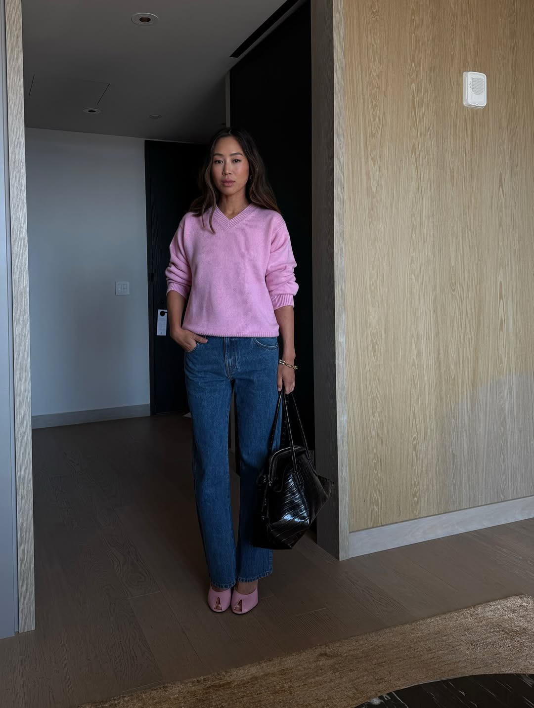 Aimee Song wearing a pink V-neck sweater from Amiya