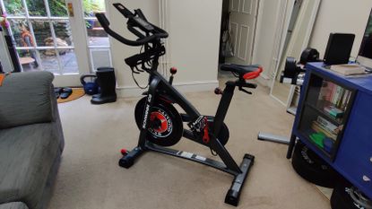 the subject of this review, the Schwinn 800IC exercise bike, placed in a busy room surrounded by home weights and furniture