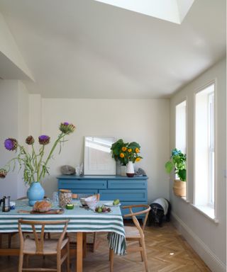 white dining room with wooden floors and blue dresser