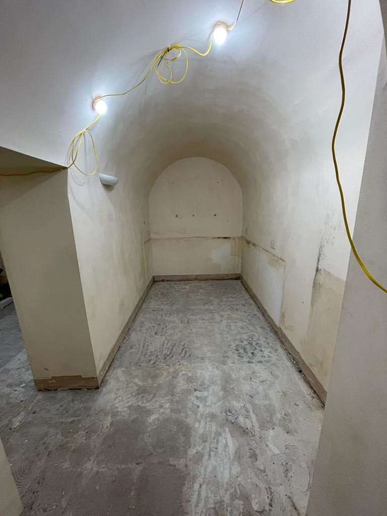 A bare room inside the old air raid shelter with curved ceiling and brick walls