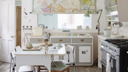 white kitchen with map print blind and white table and chairs and cooker