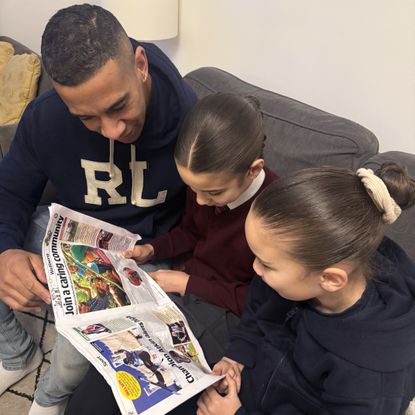 Mr Parker-Lab reading The Week Junior with his daughters