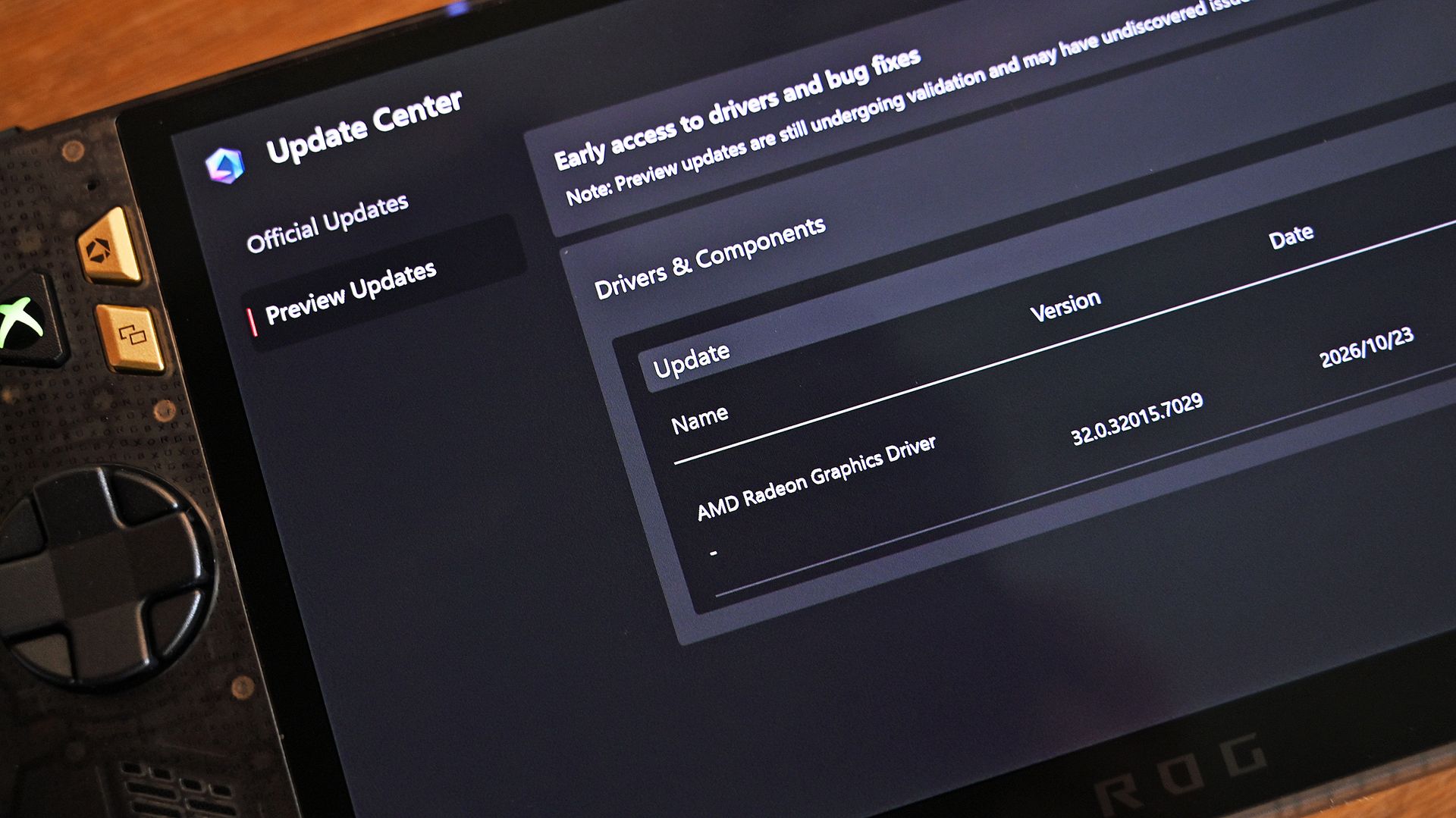 Close-up angled view of the ROG Ally screen displaying the Update Center with a preview update for AMD Radeon Graphics Driver version 32.0.32015.7029.