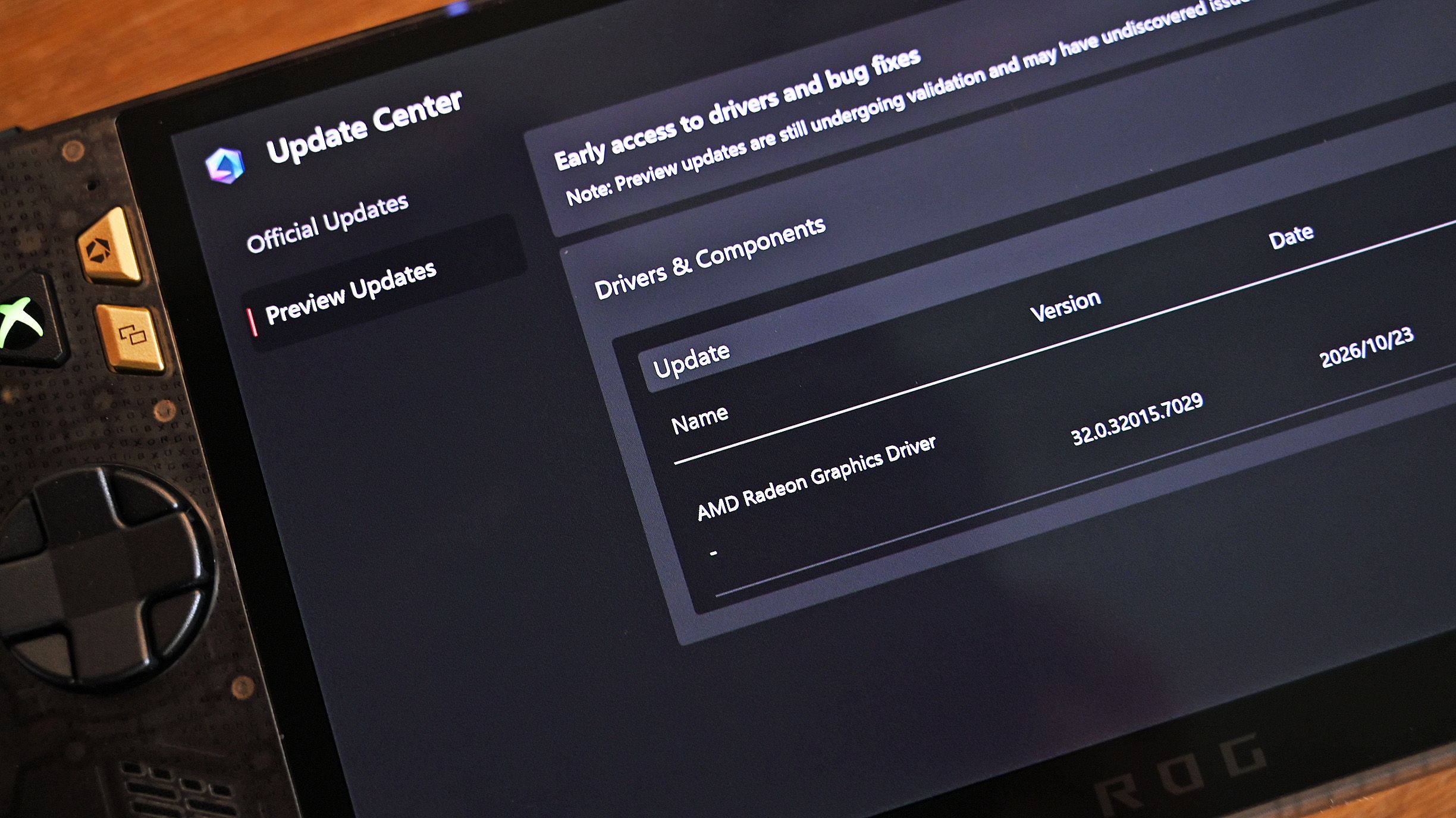 Close-up angled view of the ROG Ally screen displaying the Update Center with a preview update for AMD Radeon Graphics Driver version 32.0.32015.7029.