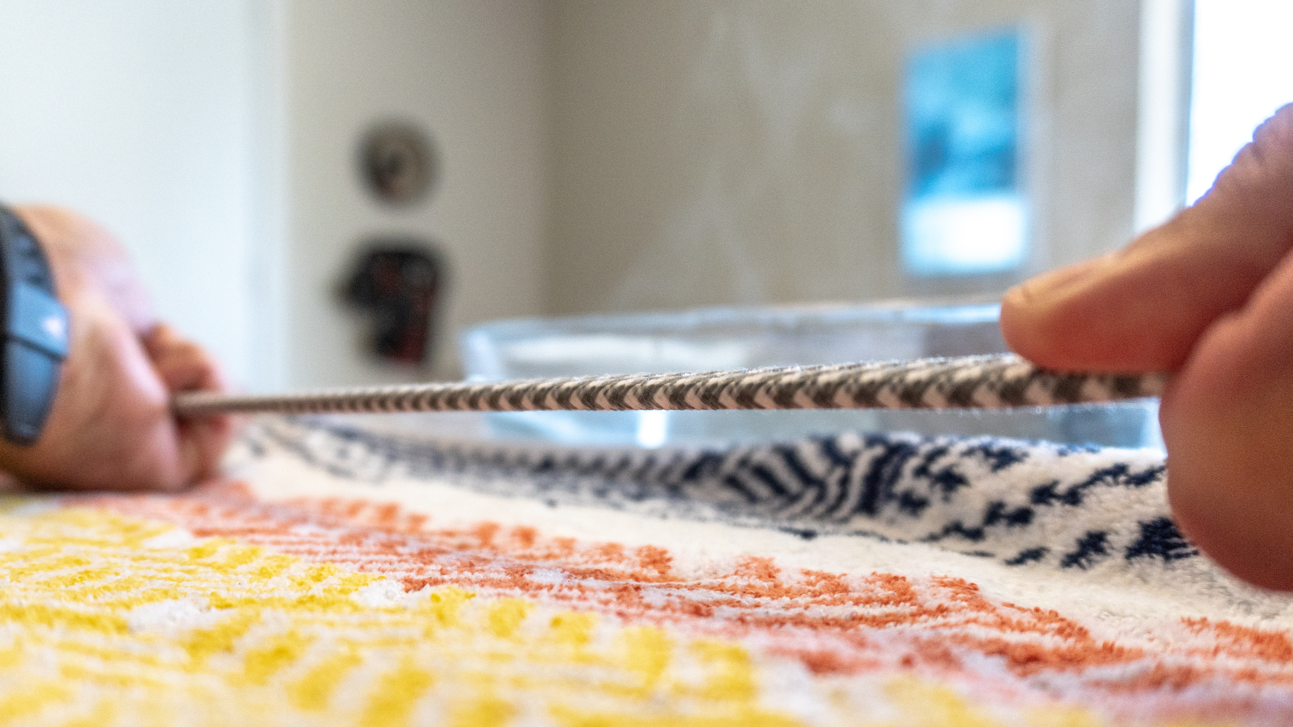 A person pulling a braided cable taut after submerging it in hot water