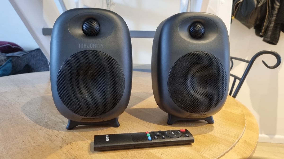 The Majority D80 Active Bluetooth Speakers on a wooden table with the included remote