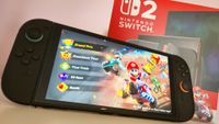 Photo of the Nintendo Switch 2 handheld running Mario Kart World sitting in front of a red Switch 2 box.