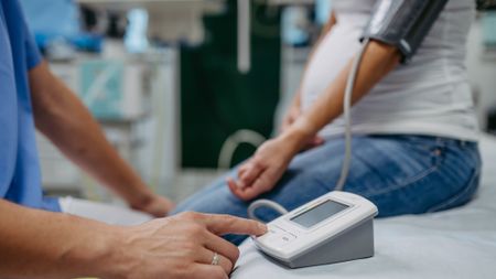 Pregnant woman with blood pressure monitor