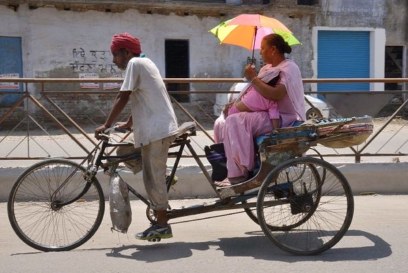 A woman tries to shield herself from the sun. 