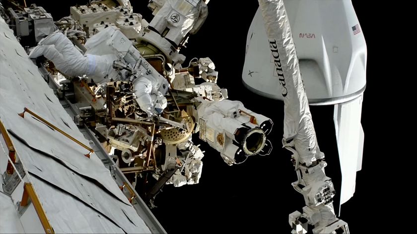 an astronaut in a white spacesuit works outside a space station opposite a space capsule