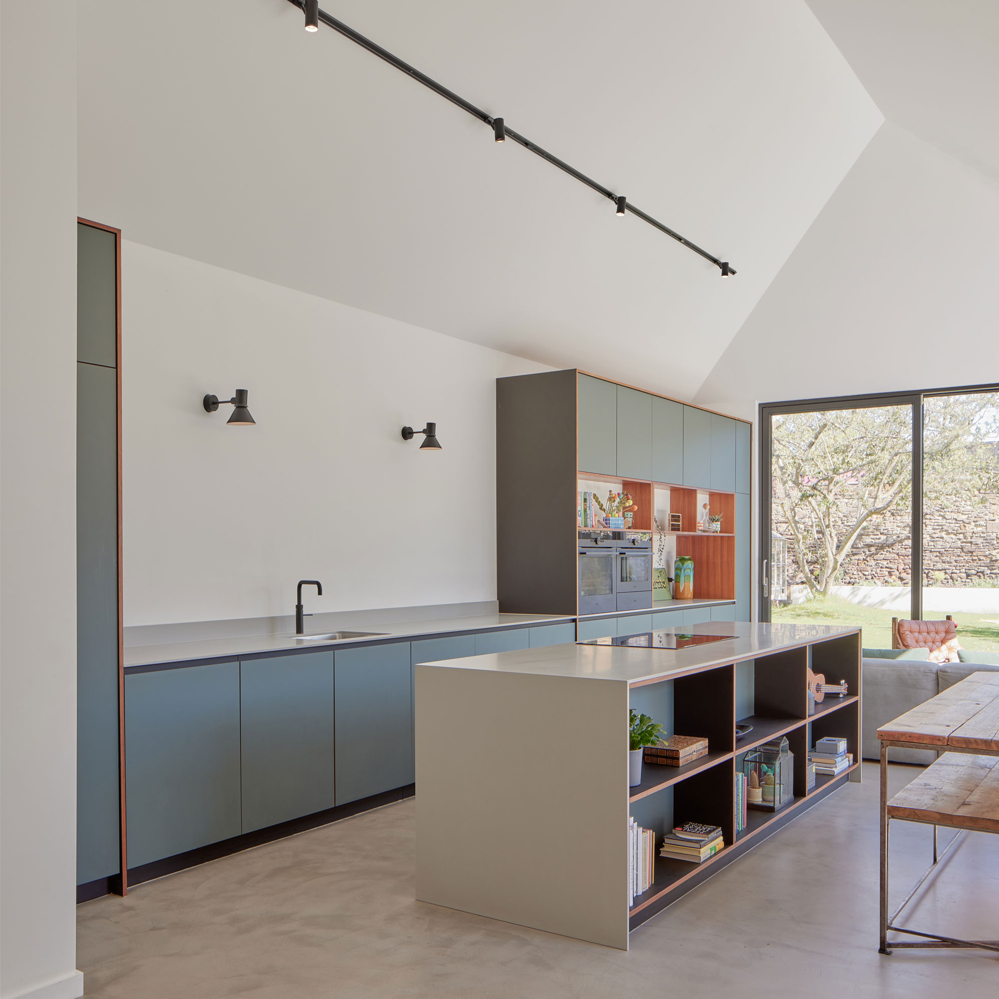 a pale blue plywood kitchen with white kitchen island