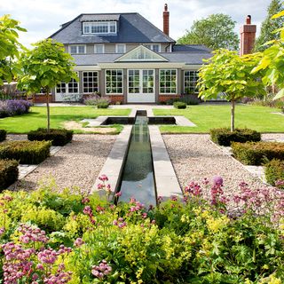 villa with white window and green lawn with waterpond