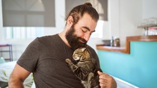 Man cuddling cat