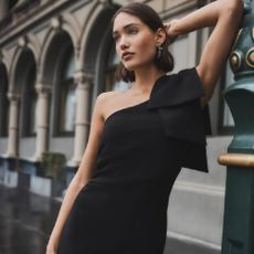 A model wearing a one shoulder black dress from Forever New.