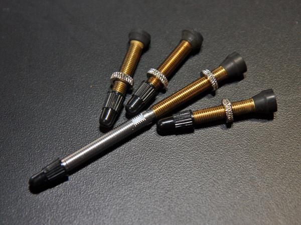 NoTubes' new universal valve stems (third and fourth from left) supposedly now work for nearly all rims and are less likely to pull through than the old Olympic ones. New fully threaded extensions allow for easier conversions on deep-section road rims, too.