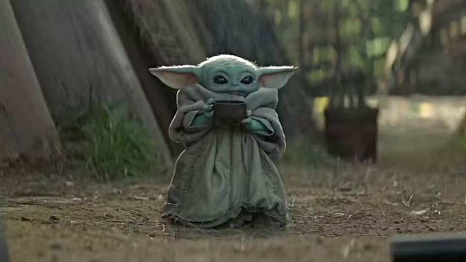 an image of baby yoda sipping on a coffee cup