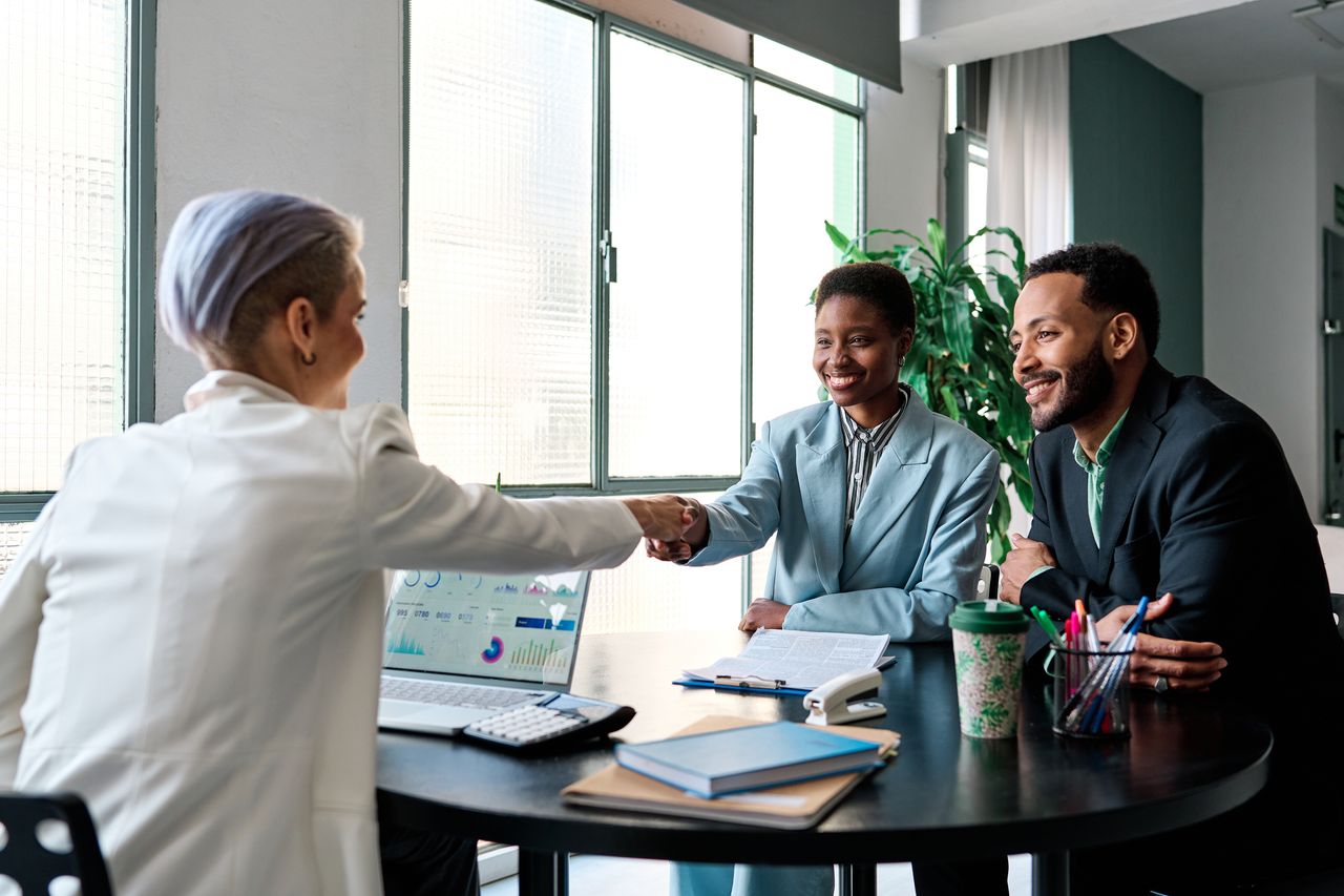 couple shaking hands with businesswoman