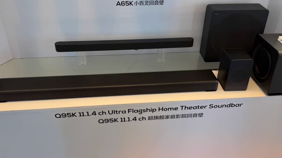 The TCL Q95K soundbar on a stand at a press event.
