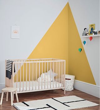 nursery with white walls and yellow corner paint feature