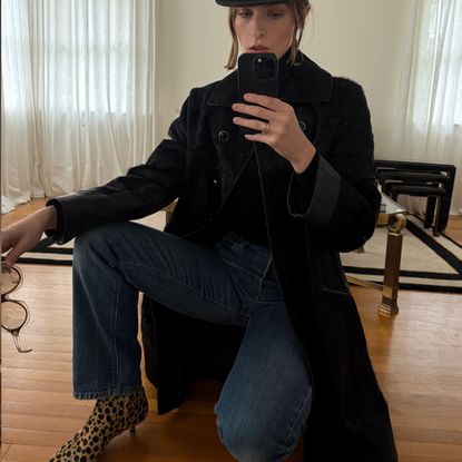 Christie Tyler kneeling on the floor wearing a black coat next to an image of a bag