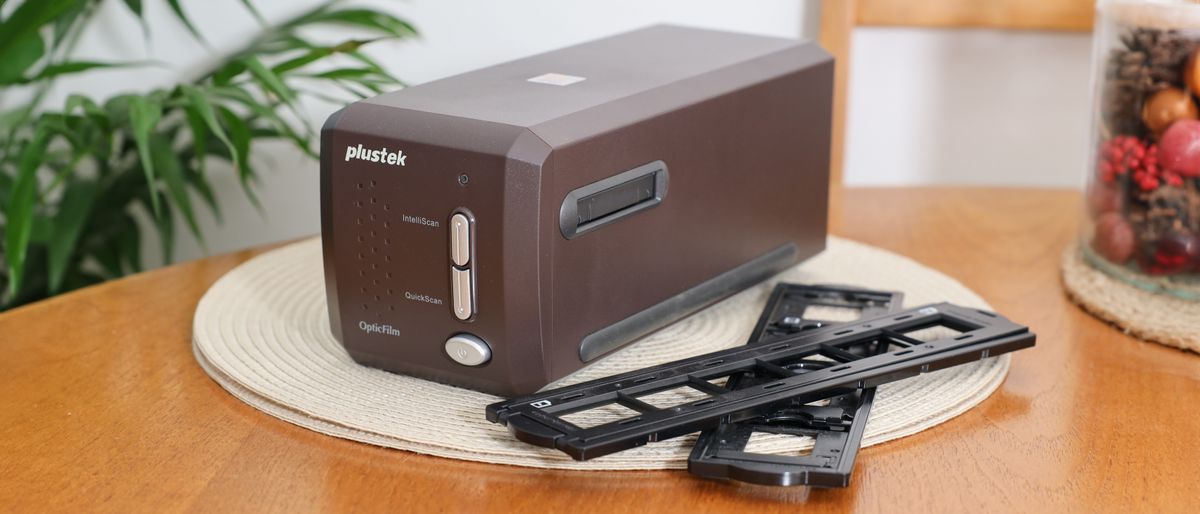 Plustek OpticFilm 35mm film scanner on a wooden table with two film holders