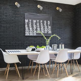 Black brick walls with wooden flooring and dinning table with chair
